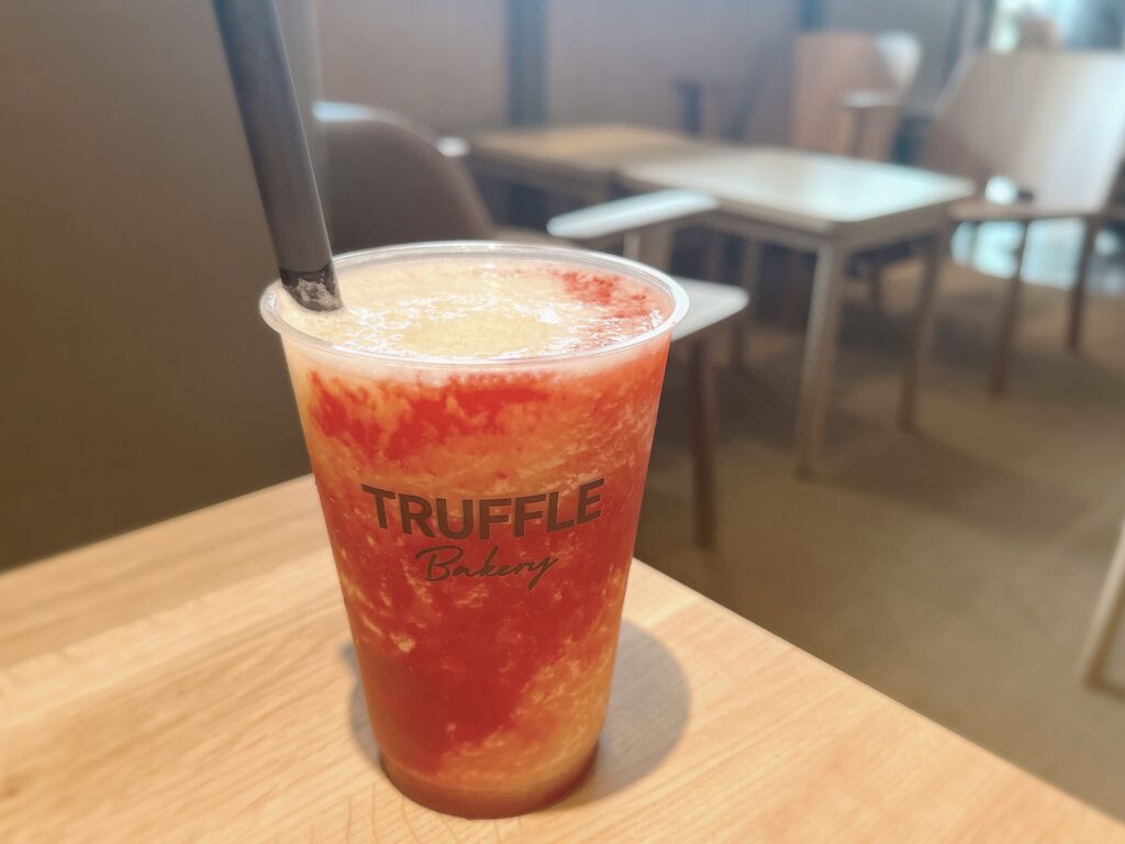 テーブルの上に置かれたドリンクの写真。赤っぽいピンク色と白の美しいマーブル模様。