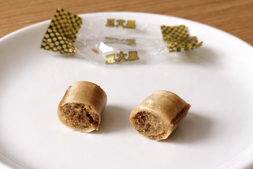 有平糖の断面。茶色い飴の中にきなこのペーストが入っている。