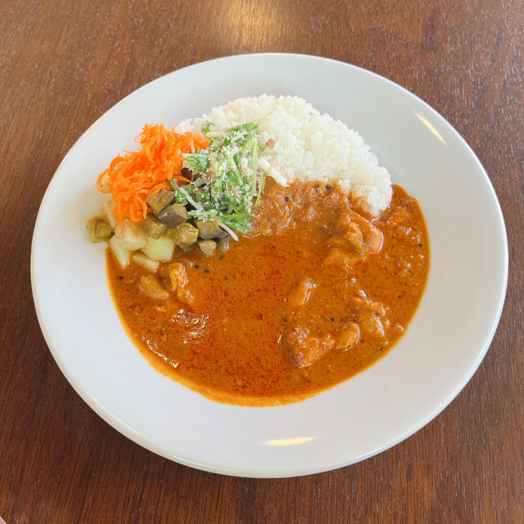 白い皿にチキンカレーが盛られている