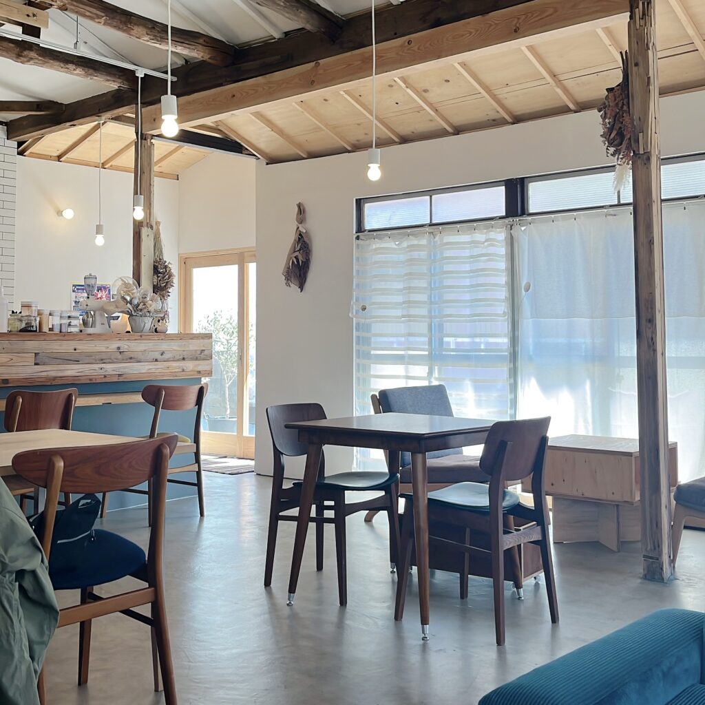 店内の写真。木製家具のテーブル席と奥にカウンター席がある。