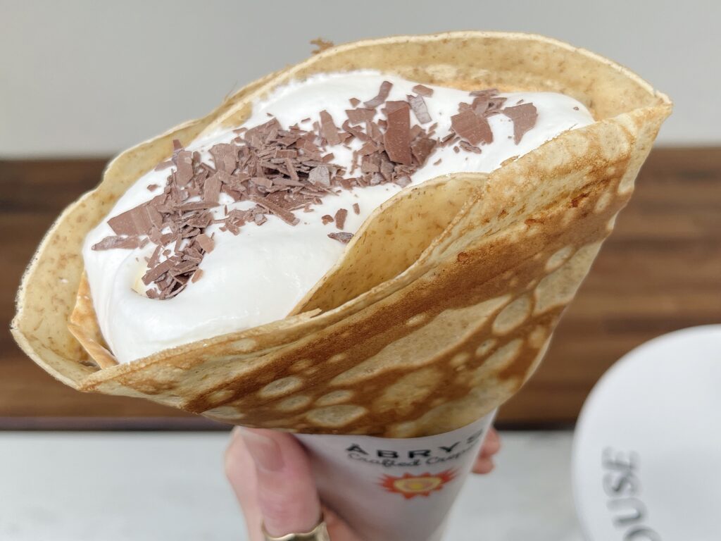 クレープを上から見た写真。たっぷりのホイップに生チョコがかけられている