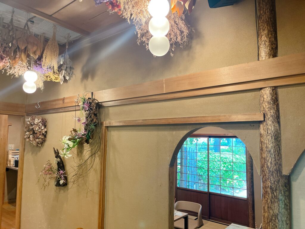 かやぶき色の壁、天井には華やかなドライフラワーがつるされている。