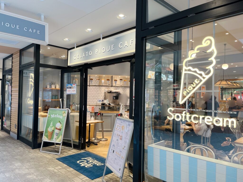 店舗外観。ガラス張りでソフトクリームやクレープの形のネオンサインがあしらわれたおしゃれな店頭の写真