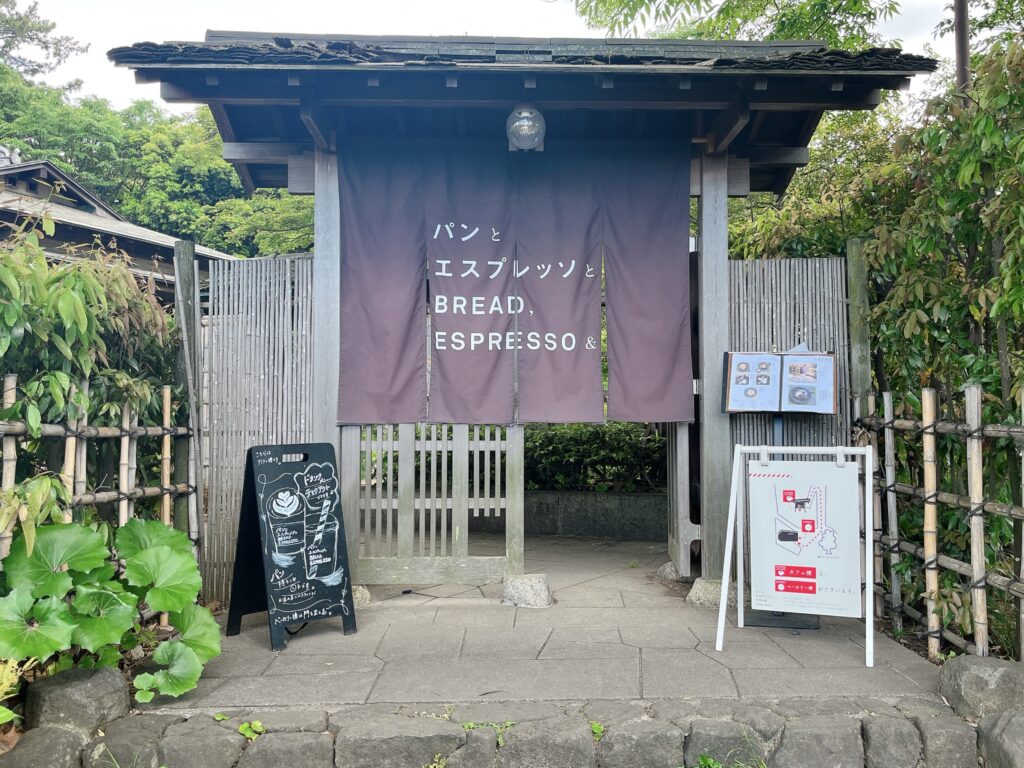 店舗外観。日本家屋の表門に店名が書かれた暖簾がかけられている。