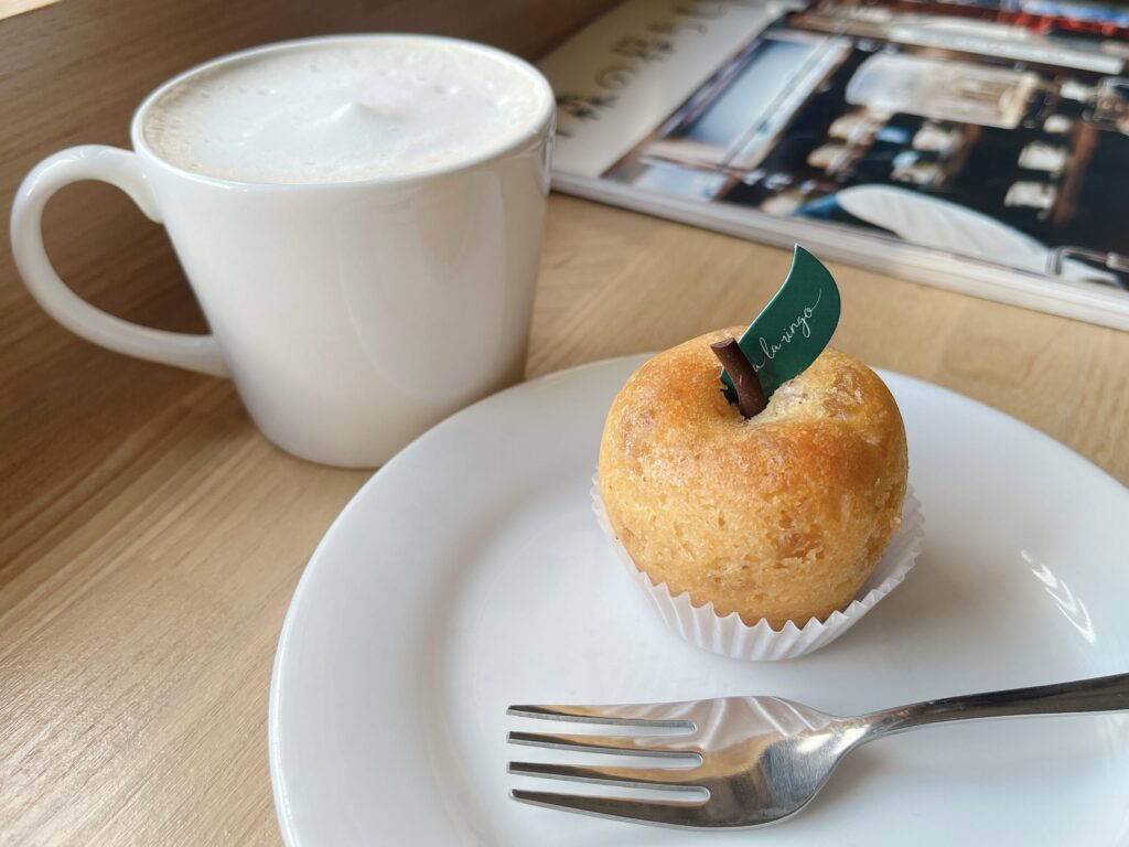 りんごの形をしたパウンドケーキと、白いカップに注がれたカフェオレの写真