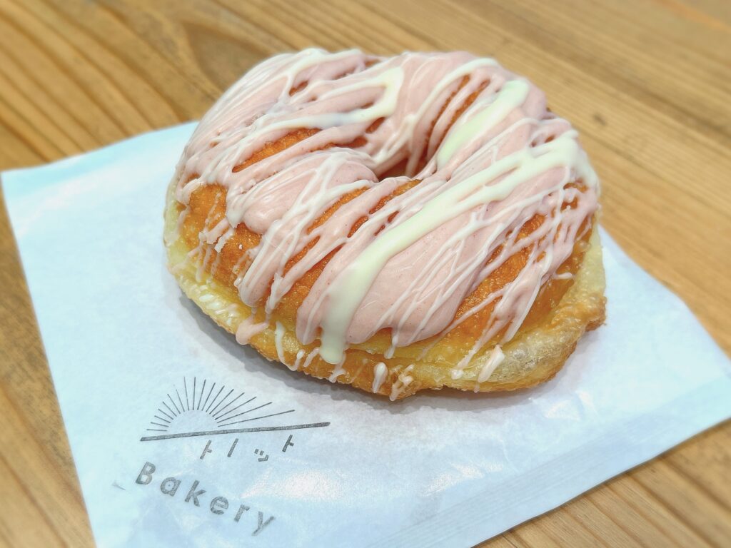 オーソドックスなドーナツの上にイチゴとホワイトのチョコがかかっている写真