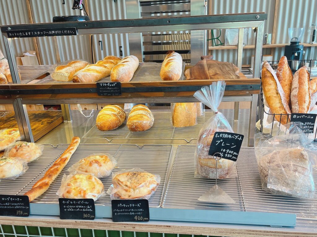 バゲットやチーズブールなどが並ぶ棚の写真