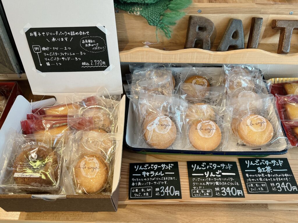 木製のカウンターのうえに並ぶ焼き菓子。りんごバターサンドが3フレーバー展開されている